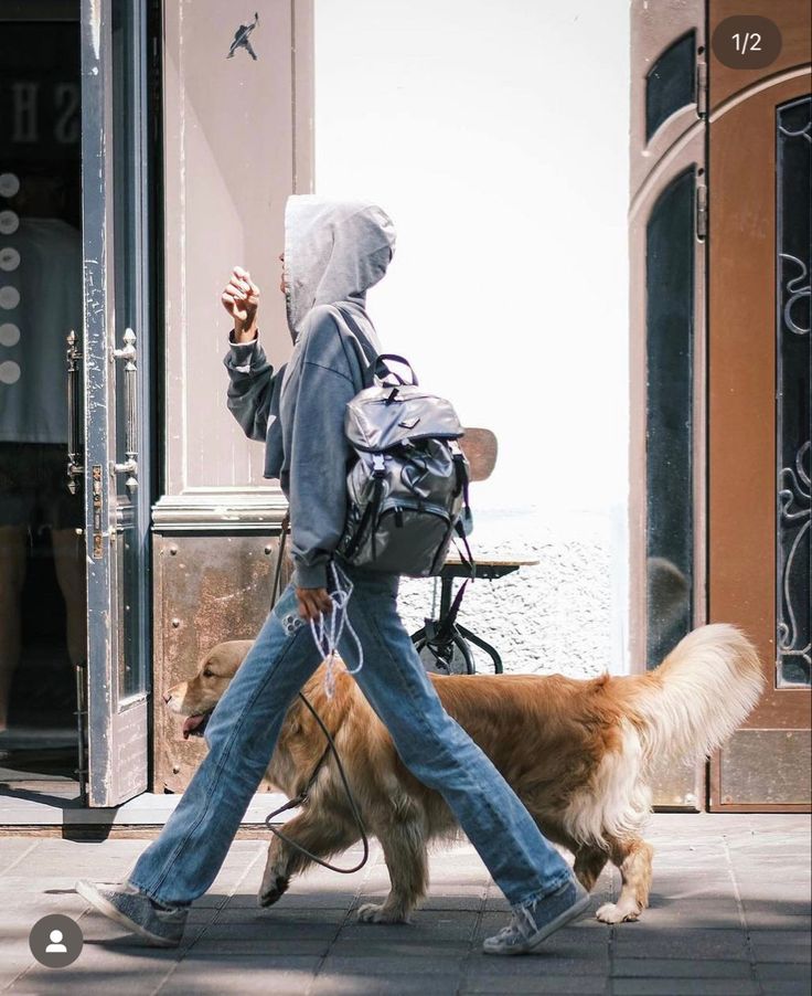 a person with a backpack and dog walking down the street