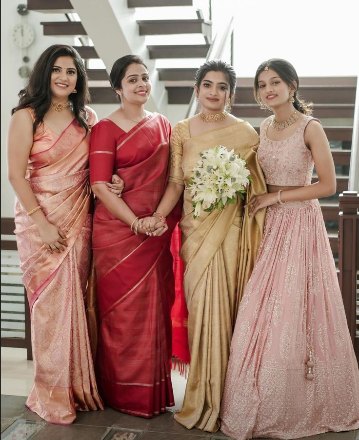 three women in sari standing next to each other