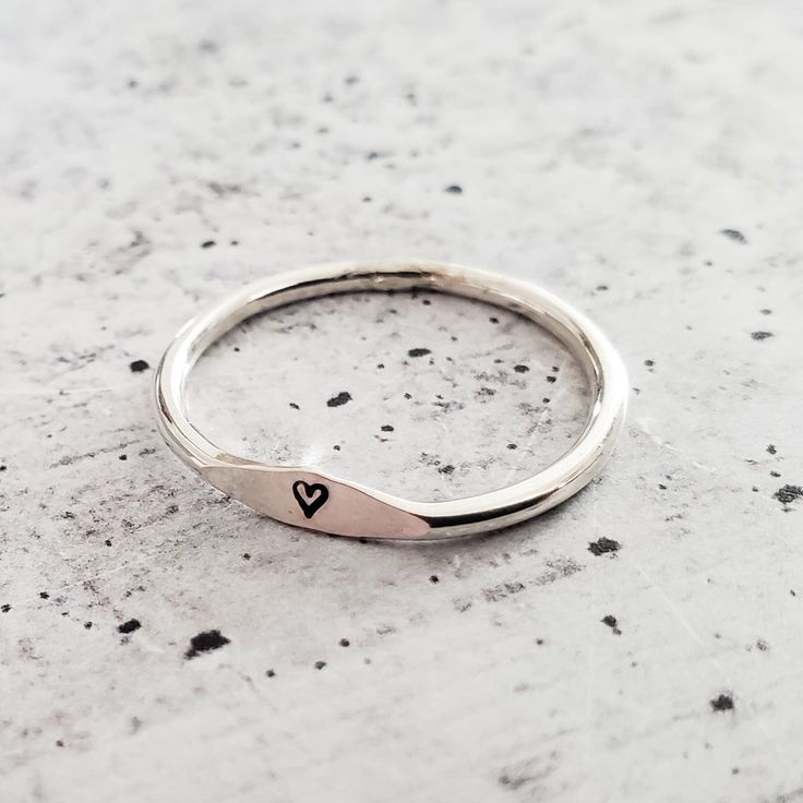 This dainty and charming ring is hand-crafted from high-quality sterling silver, ensuring both durability and style. Choose your favorite initial to be hand stamped on the ring, making it a delightful and meaningful gift for yourself or someone special. With meticulous precision, we create a unique design that adds a playful flair to the ring's overall allure. Express your individuality and show off your style by stacking this fabulous Sterling Silver Initial Ring with other favorites. Whether y Minimalist Stackable Rings For Gifts, Minimalist Stackable Rings For Gift, Everyday Sterling Silver Stackable Engraved Ring, Minimalist Sterling Silver Ring For Gift, Dainty Sterling Silver Initial Ring For Everyday, Dainty Personalized Silver Heart Ring, Simple Toe Ring Jewelry Gift, Minimalist Engraved Initial Ring In Sterling Silver, Sterling Silver Minimalist Initial Ring For Anniversary