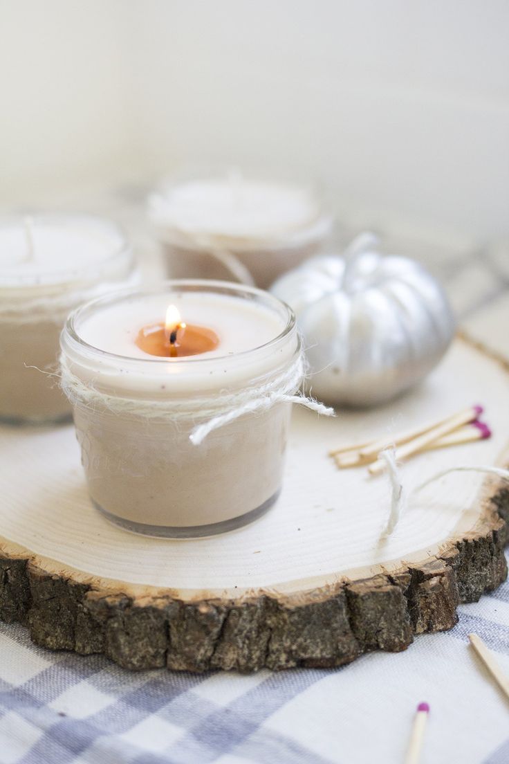 three candles sitting on top of a piece of wood