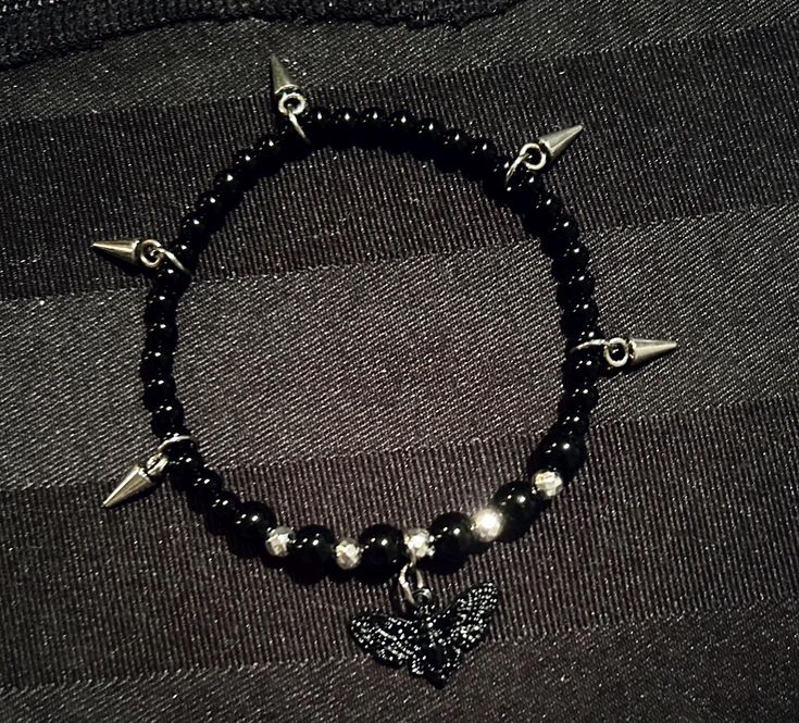 Add a little alternative goth touch to your look! (already gorgeous and unique The contrast of the black and silver pearls as well as the 5 small studs, add style to your wrist and your outfit🖤 A pretty black butterfly charm 🦋 adds the romantic finishing touch! *Elastic bracelet of approximately 18cm. *Can be customized and made smaller or larger: leave me the desired size in a message. *6mm and 4mm black agate beads *4mm silver plated hematite beads. *Black butterfly charms in black metal all Goth Bead Bracelet, Edgy Black Beaded Jewelry, Black Edgy Bracelets As Gift, Alternative Style Black Bracelets As Gift, Alternative Style Black Bracelet Gift, Alternative Style Black Bracelet For Gift, Edgy Black Bracelet For Festivals, Edgy Black Bracelet For Festival, Edgy Black Festival Bracelet