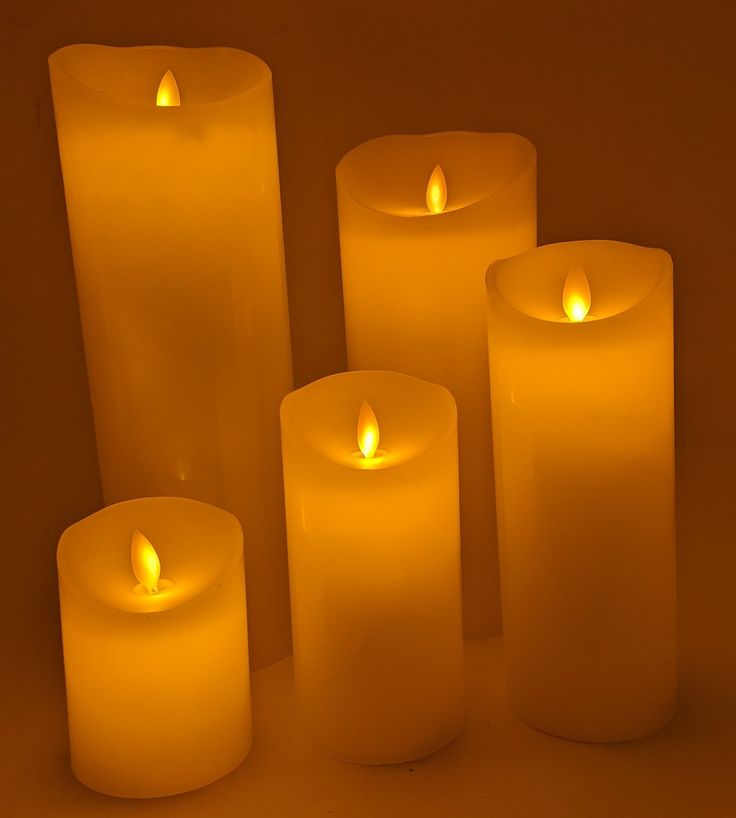 five lit candles sitting next to each other