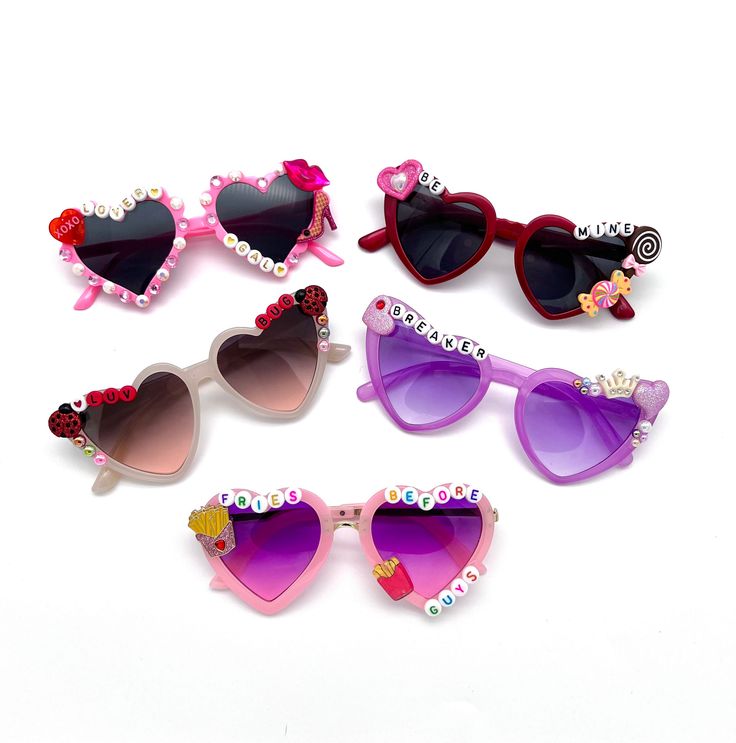 "VALENTINE'S SUNNIES!! These are so adorable-- Each pair is handcrafted by me. Using various beads, Charms, Rhinestones, and fun details! 💌💝 *4 options available-- Choose your style:  1.  BE MINE 2. HEARTBREAKER 3. LOVER GAL 4. LUV BUG * Anti-Glare * UV Protection (UVA & UVB) * Durable and shatterproof  * They open and close smoothly  * Each item is made to order and will be ready to ship in 5-7 business days! If you need your order sooner. Please check out my \"RUSH ORDER OPTION\".  https://www.etsy.com/EyeCandyandFluff/listing/1286351273/rush-my-order-please *SHOP DISCLAIMER/WAIVER!  * Do NOT let your child put the sunglasses in their mouth as beads can become detached.    Always monitor and supervise while children are wearing these. The shop assumes no responsibility for sunglasses m Pink Fun Sunglasses With Glass Lenses, Fun Pink Glass Sunglasses, Novelty Sunglasses With Uv Protection For Gift, Novelty Sunglasses With Uv Protection As Gift, Playful Sunglasses For Valentine's Day Party, Fun Handmade Sunglasses As A Gift, Playful Party Sunglasses For Valentine's Day, Heart-shaped Glass Sunglasses For Gift, Heart-shaped Glass Sunglasses As Gift