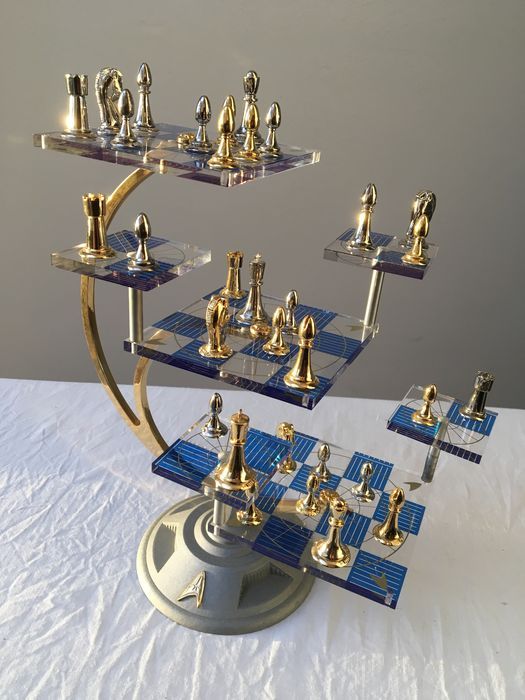 a chess set is shown on a table with blue and gold pieces in the middle