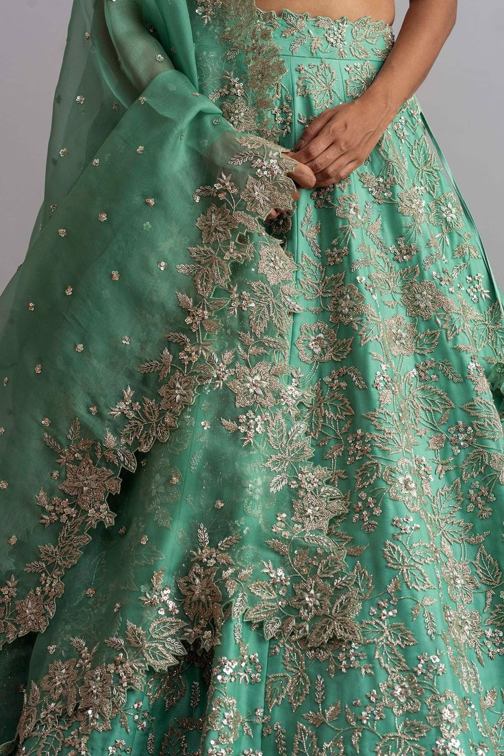 Sea-green organza lehenga with cutdana work, floral motifs and cutwork hem. Comes with embellished blouse and dupatta.
Components:3
Embroidered
Neckline:Square
Sleeve Length:Half
Fabric:Organza
Color:Green
Kamar tassels
Tie-up cutout back
Cutwork detail
Note: Cancan worn by the model is not for sale - Aza Fashions Green Lehenga With Intricate Embroidery For Festive Occasions, Festive Green Lehenga With Intricate Embroidery, Green Unstitched Lehenga With Intricate Embroidery, Unstitched Green Lehenga With Intricate Embroidery, Designer Green Lehenga With Sheer Dupatta, Green Lehenga With Resham Embroidery For Reception, Anarkali Green Lehenga With Intricate Embroidery, Green Lehenga With Intricate Embroidery For Reception, Green Gown With Intricate Embroidery And Traditional Drape