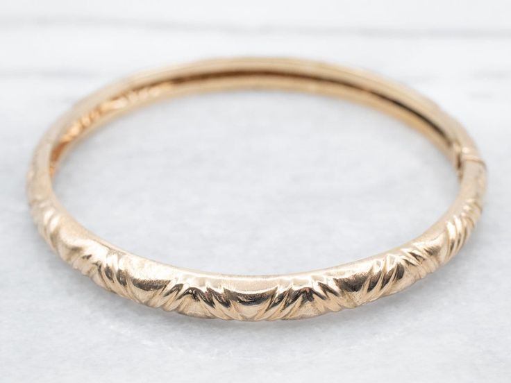 "This vintage bangle bracelet is full of romance and elegance! A simple patterned design is accented by a wonderful patina that adds wonderful depth to the polished 18-karat gold. The hinged design allows for easy on-and-off functionality. Metal: 18K Yellow Gold Width: 6.0 mm Inside Circumference: 7 Inches Marks: \"GM P\" Stamped on the clasp To view a video of this piece check out the link below: https://vimeo.com/810180149 SKU #: A21533 Each piece has been identified and graded by a Graduate Gemologist who has been certified by the Gemological Institute of America (GIA). We have six brick-and-mortar storefronts in Maine, Massachusetts, and New Hampshire and have been in business for over 25 years! Please visit our Shop's About Page or our website for more information about our jewelry. F Bangle Stacking, Custom Bangle, Gold Bangle Set, Vintage Bangle Bracelets, Boho Bangle, Mothers Bracelet, Aquamarine Pendant, Vintage Bangles, Filigree Pendant