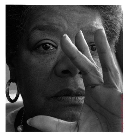 a black and white photo of a woman holding her hand up