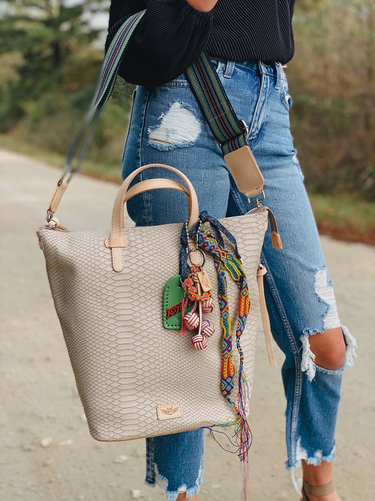 Our Thunderbird Sling is a versatile bucket bag that makes it easy to store your essentials in style. Our sling can be worn in multiple ways: as a crossbody, over the shoulder, or held by its leather handles. The bag features our embossed snake print exterior. A laptop up to 13" fits comfortably inside. Details & Sizing Interior slide pocket, credit card pocket, and lanyard Includes two detachable straps: a leather shoulder strap and an adjustable woven crossbody strap Natural, untreated lea Leather Handles, Luggage Tags, Snake Print, Crossbody Strap, Sling Bag, Leather Handle, Lanyard, Straw Bag, Bucket Bag