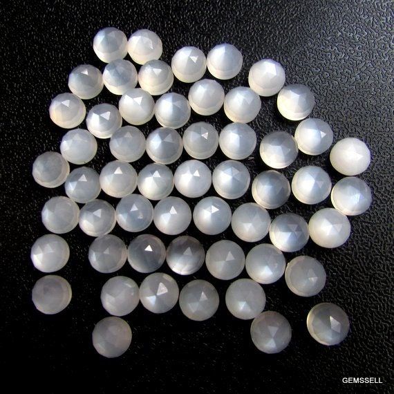 several large white glass beads on a black surface