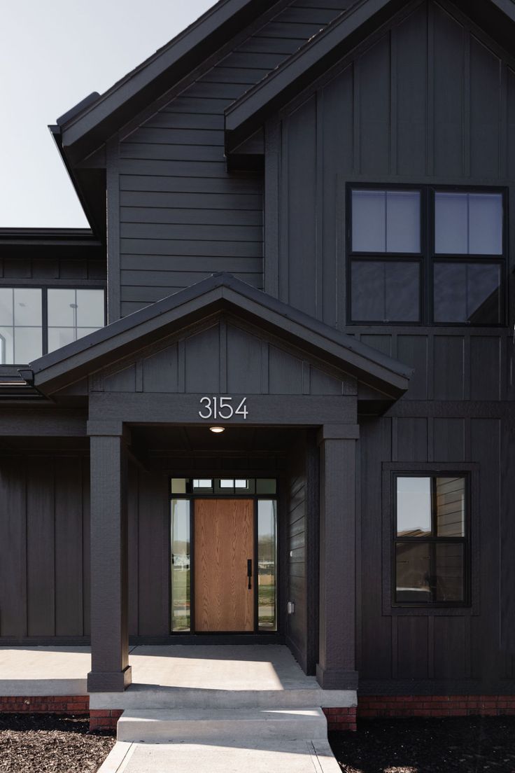 the front entrance to a large house with a wooden door and number on it's side