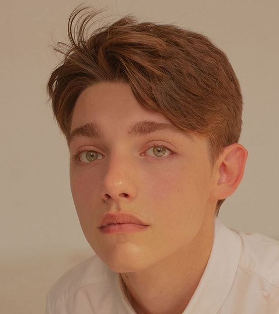 a young man in a white shirt and tie looking off to the side with his eyes wide open