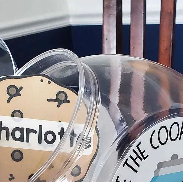 two cookie tins sitting next to each other on top of a wooden chair with the word charlotte written on them