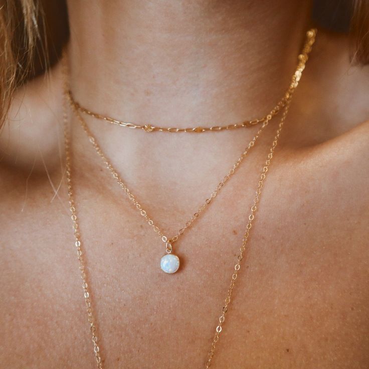 Our handmade necklace featuring a lovely round white opal pendant is a true gem, crafted with Gold Filled materials. Opal has long been regarded as a stone of good fortune, and this pendant is no exception! It's the perfect accessory for any occasion, adding a touch of classic beauty to her style. Our opal necklace is simply delightful, the perfect gift to enhance her daily look! DETAILS: 14kt Gold Fill Gemstone: White Opal Gemstone Shape: Round Gemstone Size: 6 mm ~HANDMADE WITH LOVE ~ WATERPROOF ~ NEVER PLATED PROCESSING TIME: Processing time for this item is 1-5 business days prior to shipping. As soon as your item ships, Etsy will send out a shipping notification that includes tracking information. Our packaging is important to us! all jewelry is shipped in a beautiful biodegradable mi Delicate Round White Necklace, Dainty White Round Necklace, White Necklace With Delicate Chain, White Round Dainty Necklace, Delicate White Opal Jewelry, Minimalist Opal Jewelry With Delicate Chain, Minimalist White Round Necklace, Gold Opal Round Beads Necklace, Gold Opal Necklace With Round Beads