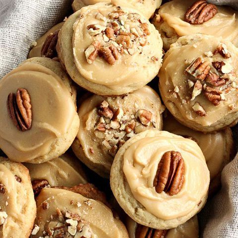 a basket filled with cookies covered in frosting and pecans on top of a table