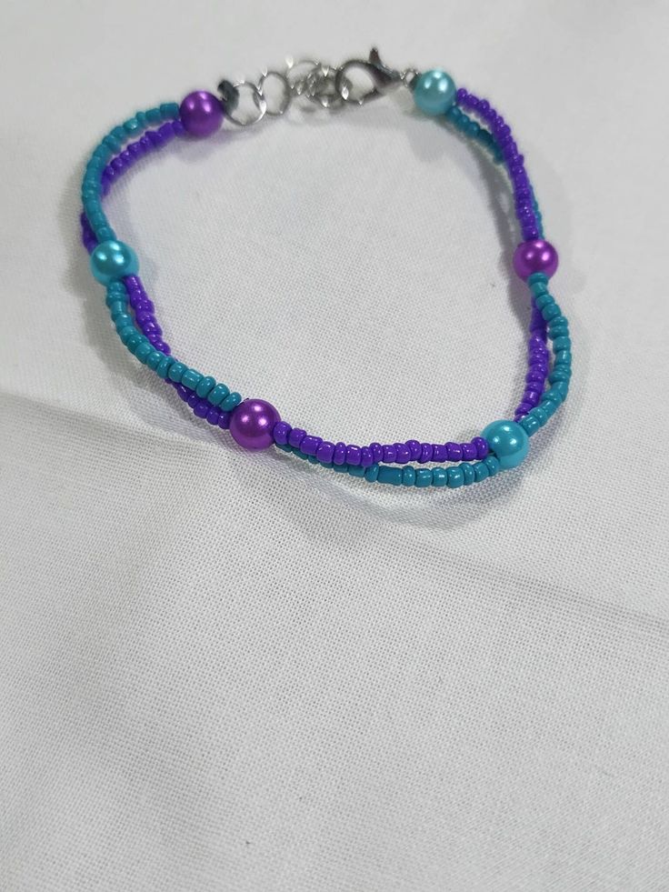 6.5" to 7.5" adjustable glass, seed beaded bracelet in two colors, purple and turquoise Purple Beaded Chain Bracelets With Round Beads, Purple Beaded Chain Bracelet With Round Beads, Adjustable Purple Bracelets With Tiny Beads, Adjustable Purple Bracelet With Tiny Beads, Adjustable Purple Beaded Friendship Bracelets, Adjustable Purple Beaded Necklace With Tiny Beads, Turquoise Beaded Braided Bracelets, Turquoise Braided Bracelets With Round Beads, Adjustable Purple Beaded Bracelet With Beaded Chain