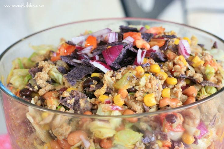 a glass bowl filled with salad and vegetables