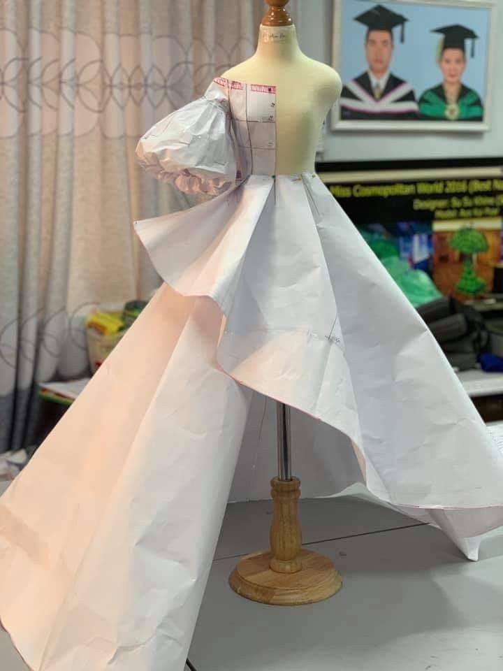 a dress made out of paper sitting on top of a mannequin