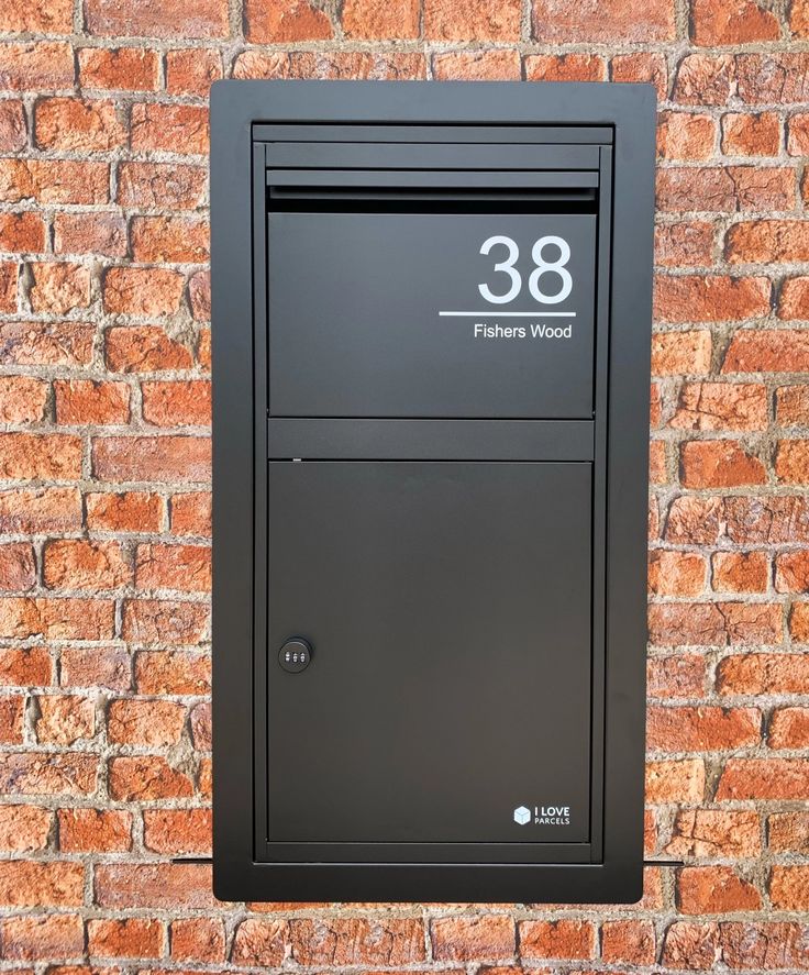 a black mailbox mounted to a brick wall with the number eighty eight on it