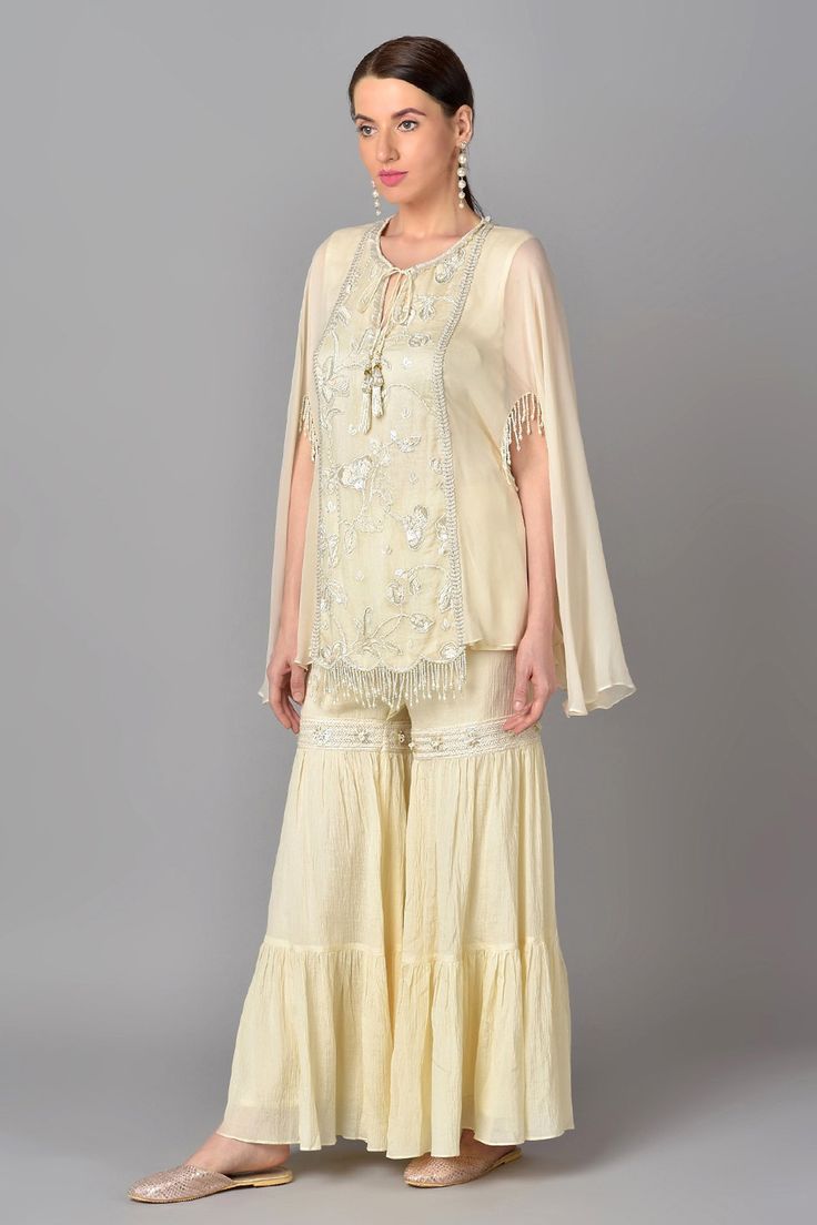 Ivory kurta with sequin work and floral embroidered motifs. Paired with tiered sharara.
Component: 2
Embroidered
Neckline: Round
Sleeve Length: Short
Fabric: Cotton Chiffon, Georgette
Color: White
Front tassel tie-up
Tassel cape sleeves - Aza Fashions Kurta And Sharara Set, Kurta And Sharara, Embroidered Motifs, White Kurta, Cape Sleeves, Sharara Set, Embroidered Neckline, Fashion App, Festival Wear