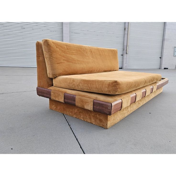 a brown couch sitting on top of a cement floor