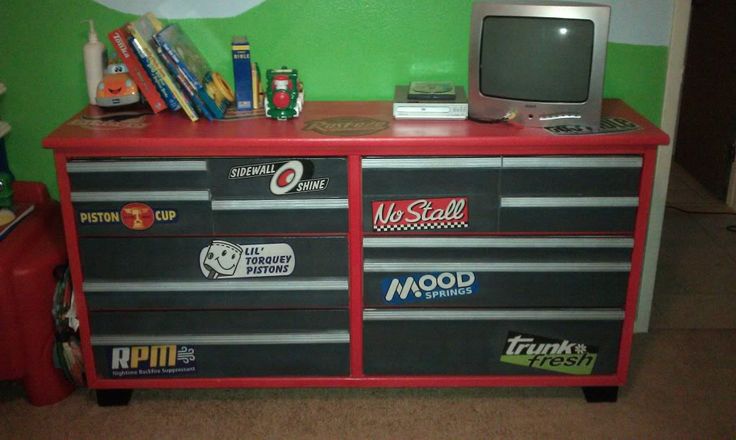 a red dresser with many stickers on it and a tv sitting on top of it