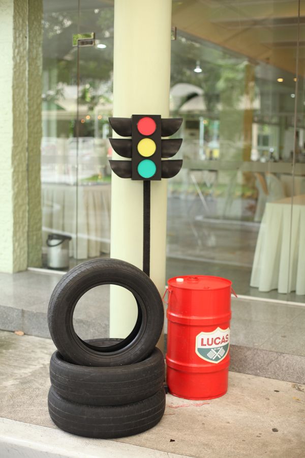 two tires and a traffic light sitting on the side of a building next to a red barrel