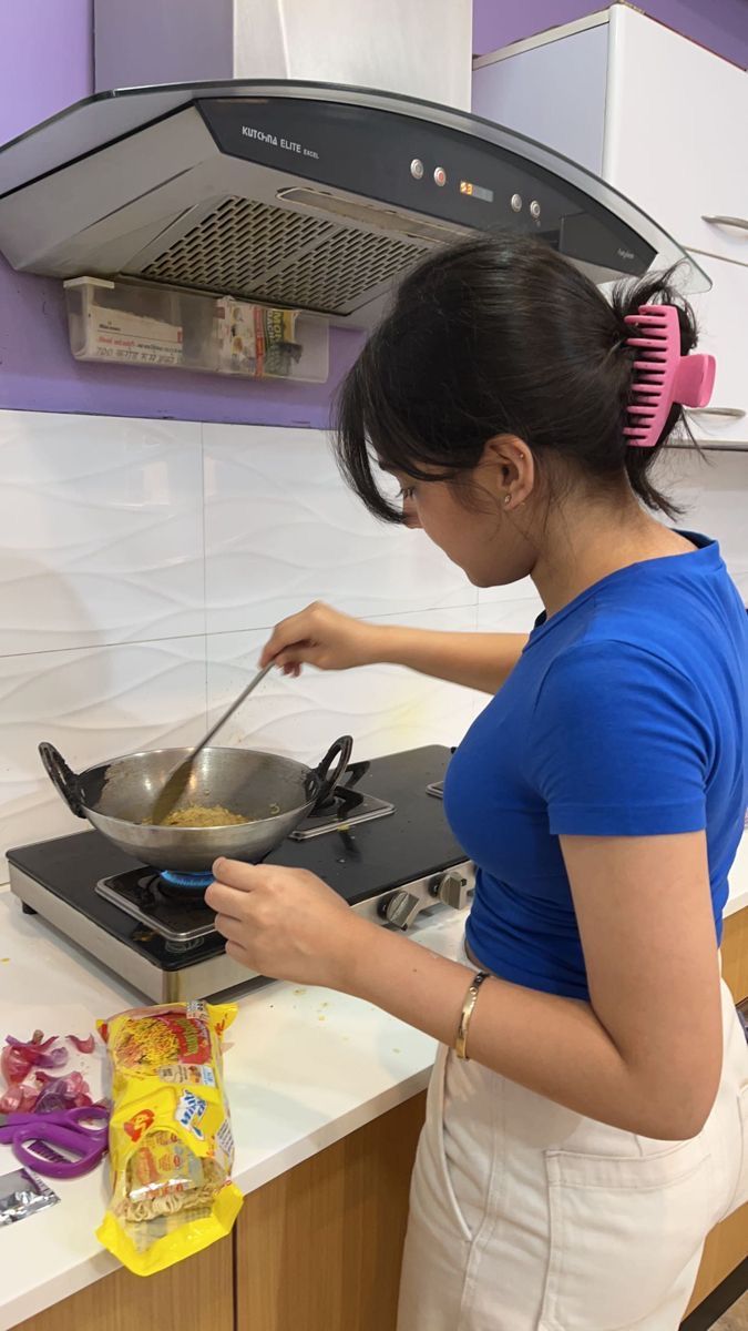 a woman cooking food on top of a stove