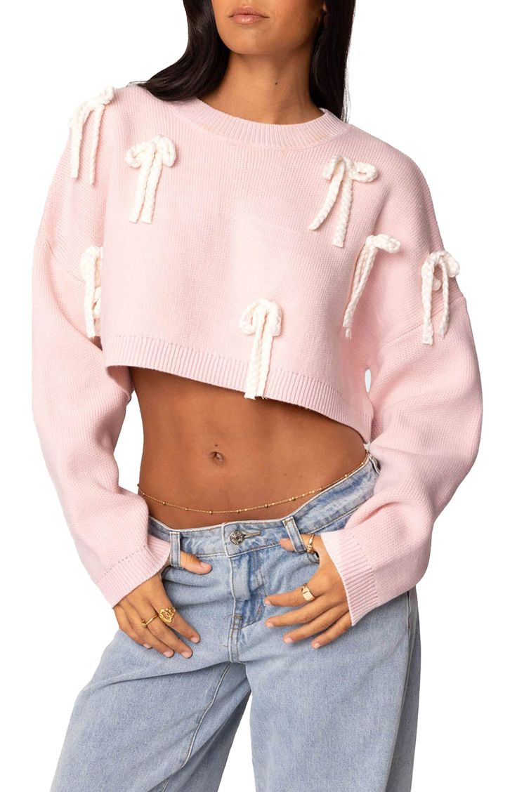 Braided bows decorate a highly cropped sweater knit in a slouchy silhouette for casual charm. Crewneck Long sleeves Dropped shoulders Ribbed cuffs and hem 100% acrylic Machine wash, dry flat Imported Coquette Sweaters, Pallett Ideas, Pink Cropped Sweater, Core Clothes, Bow Jeans, Knit Bow, Cabin Trip, Ideas Closet, Womens Hats