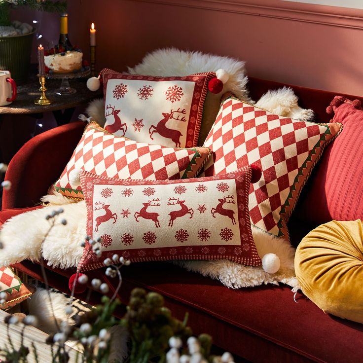 red and white christmas pillows sitting on top of a couch