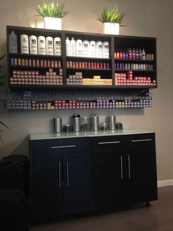 a wall mounted spice rack with spices and condiments on the shelves above it