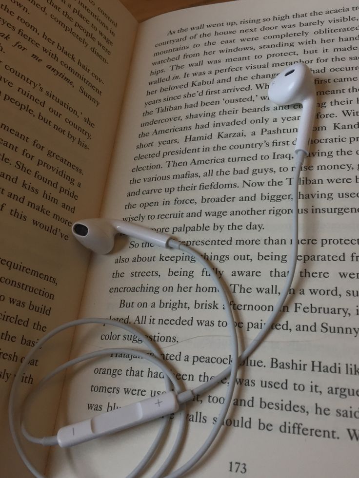 an open book with headphones laying on top of it