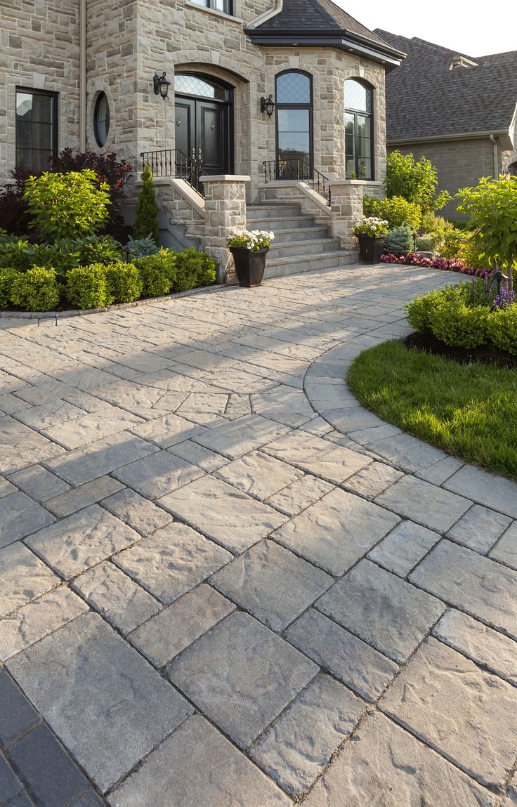 a stone walkway leading to a large house