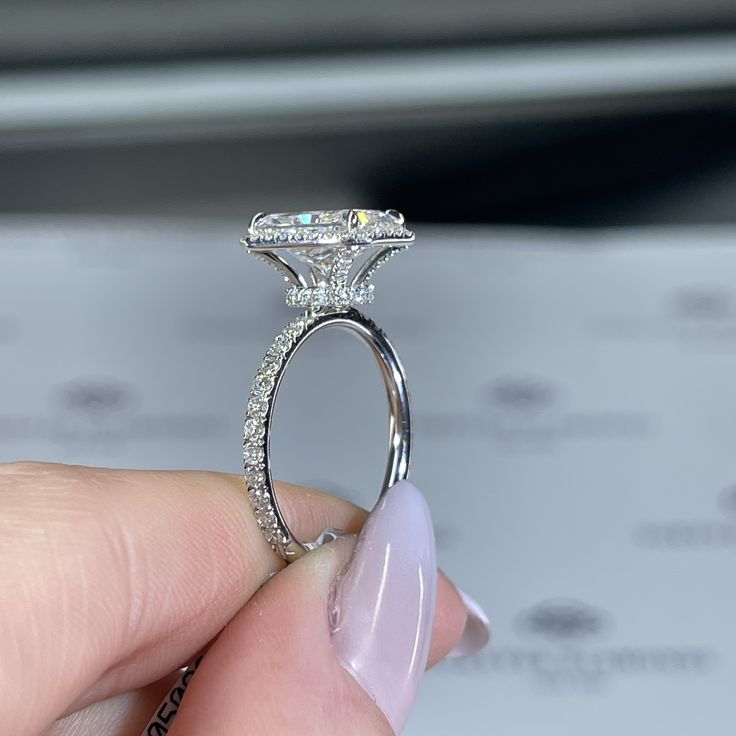 a woman's hand holding an engagement ring