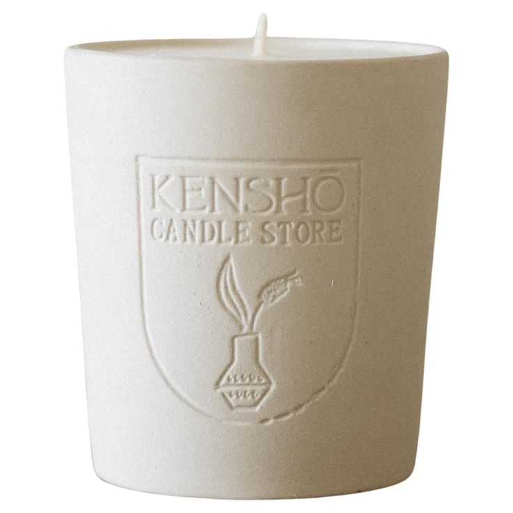 a white candle holder with the kensho candle store logo on it's side