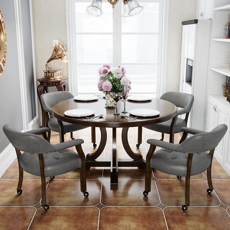 a dinning room table with chairs and a vase on the table in front of it