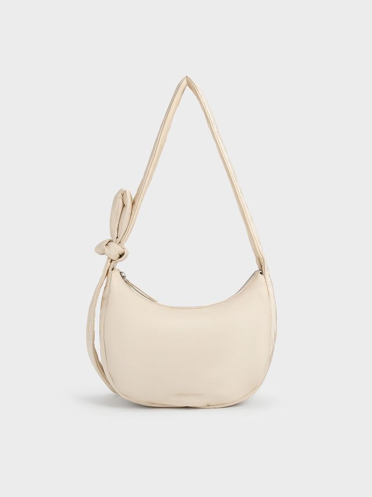 Featuring a cute and casual design, the Delilah hobo bag is the perfect everyday companion. Its minimalist design lets its soft puffy texture shine -- the versatile oat finish adds to its charm. Opening up to a spacious interior, you will be able to fit more than the essentials while the knotted strap allows you to adjust the bag to a comfortable drop length. Versatile Spring Hobo Bag For On-the-go, Beige Hobo Bag With Zipper For On-the-go, Versatile Beige Hobo Shoulder Bag, Trendy Beige Hobo Bag For Everyday, Trendy Everyday Beige Hobo Bag, Everyday Beige Hobo Bag With Single Shoulder Strap, Neutral Everyday Hobo Shoulder Bag, Neutral Hobo Shoulder Bag For Everyday, Everyday Neutral Hobo Shoulder Bag