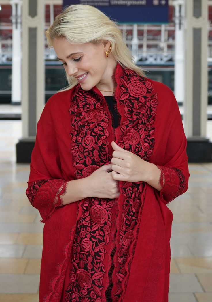 Crafted from a premium blend cashmere , this red scarf offers the perfect fusion of warmth and luxury. A vibrant masterpiece adorned with exquisite floral Gara embroidery and filigree lace panels on the long borders. The dual-colored black and red floral embroidery brings an elegant touch, reminiscent of nature's beauty, while the floral filigree lace enhances the scarf's delicate charm. The deep red color exudes a sense of passion making this scarf suitable for various occasions. Whether you ch Red Shawl With Embroidered Border, Red Shawl With Embroidered Border In Traditional Drape, Red Embroidered Shawl With Traditional Drape, Elegant Winter Scarves With Traditional Drape, Elegant Scarves With Traditional Drape For Winter, Elegant Scarf With Traditional Drape For Winter, Elegant Red Scarf For Festive Season, Elegant Red Festive Scarf, Red Shawl With Intricate Embroidery