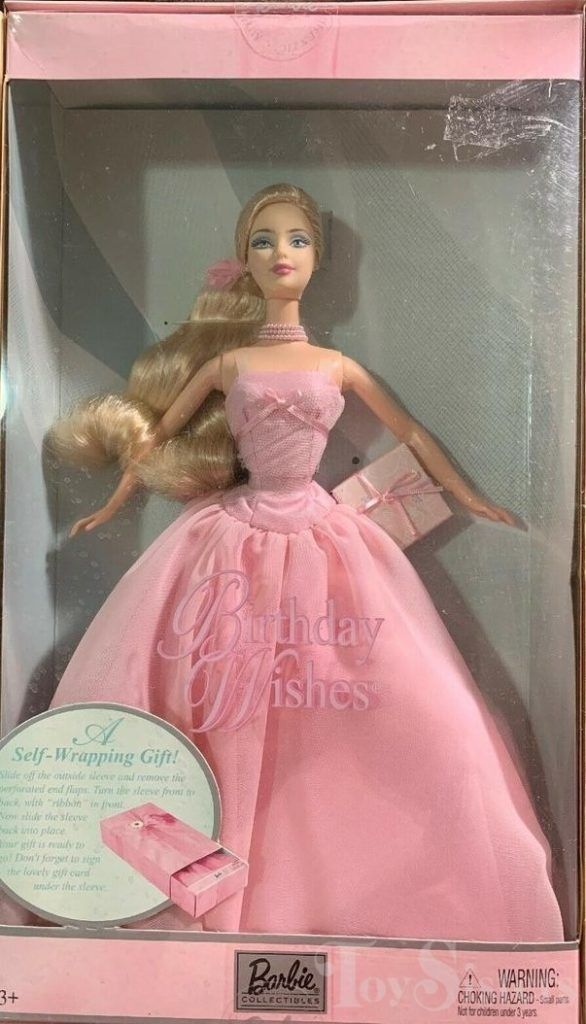 a barbie doll in a pink dress with a box on the side and an advertisement for birthday wishes