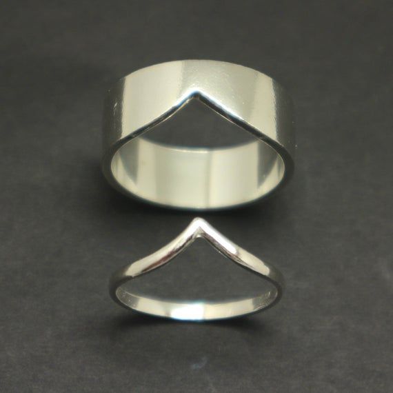 a silver ring sitting on top of a black table next to a pair of scissors