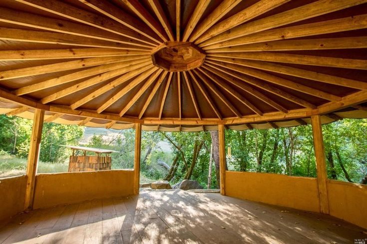 the inside of a wooden gazebo with trees in the background