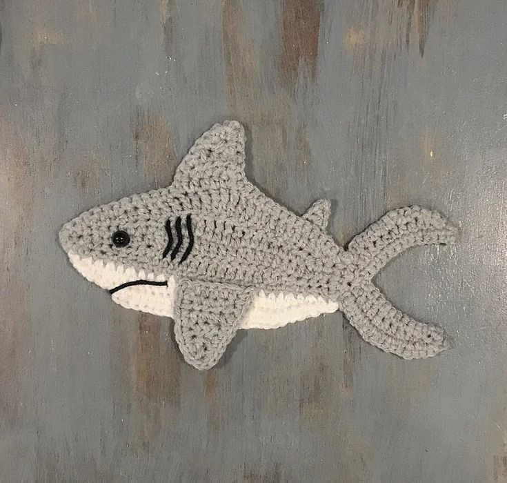 a crocheted shark on a metal surface