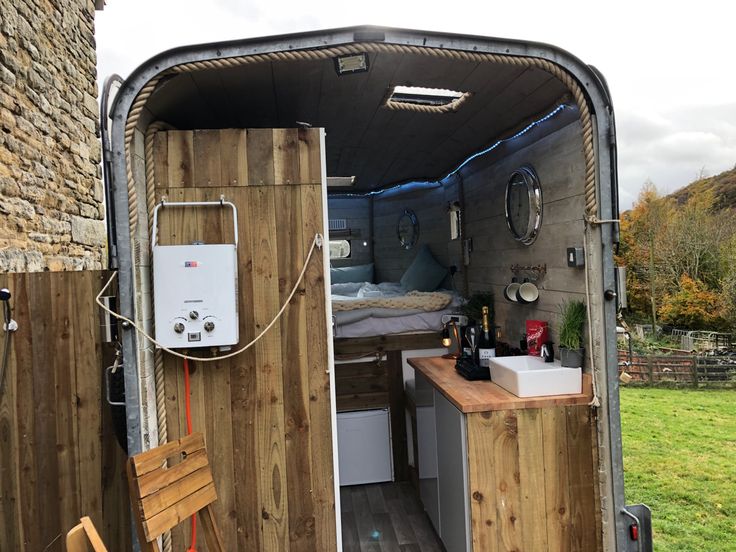 the inside of an rv with a sink and kitchenette in it, next to a brick wall