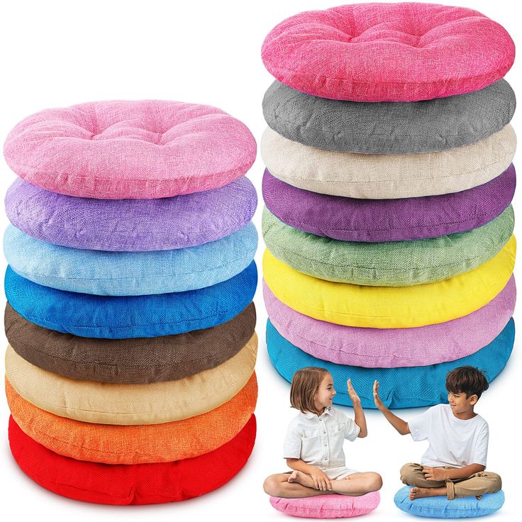 a group of children sitting on the floor in front of a stack of pillows and cushions