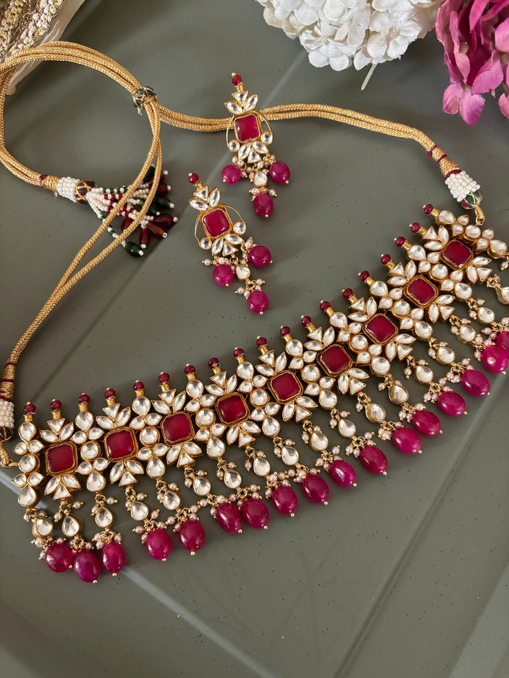 Discover the epitome of elegance with our premium necklace set. Crafted with precision and designed to turn heads, this set is a true masterpiece. Product Details: Material: Each piece is meticulously handcrafted from high-quality brass, copper, silver, Pachi Kundan, gold plated, ruby beads Choker Necklace Dimensions: Weight: 112 grams. Closure Type: Premium Dori Adjustable Size: Yes  Earring Dimensions (Per Pair): Weight: 20 grams Length: 6 cm Width: 2 cm Closure Type: Push Back Exquisite Desig Elegant Gold-plated Meenakari Jewelry Sets, Elegant Gold Plated Meenakari Jewelry Sets, Elegant Meenakari Gold-plated Jewelry Sets, Elegant Meenakari Gold Plated Jewelry Sets, Elegant Metal Kundan Necklace With Meenakari, Gold Plated Jewelry With Matching Earrings For Diwali, Diwali Gold Plated Jewelry With Matching Earrings, Kundan Yellow Gold Jewelry With Matching Earrings, Yellow Gold Kundan Jewelry With Matching Earrings