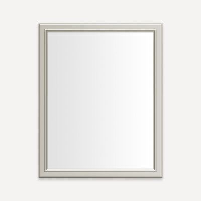 a white framed mirror on a wall with a light gray border around the frame and bottom edge