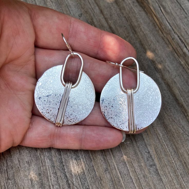 I handcraft these Circle with Lines earrings from sterling silver and add a shiny finish or Shiny with a hand textured accent. Please let me know in notes at checkout if you prefer them with hand texture Measures: @1.25" width Material: Silver (.925). All materials are hypoallergenic. These Earrings are designed and handcrafted in my studio in Concord, NH Unique Hammered Sterling Silver Earrings, Silver Oval Earrings For Everyday, Hammered Metal Earrings Gift, Hammered Metal Earrings As Gift, Unique Silver Nickel-free Earrings, Everyday Nickel Free Silver Earrings, Everyday Nickel-free Silver Earrings, Unique Everyday Hammered Earrings, Hammered Sterling Silver Round Earrings