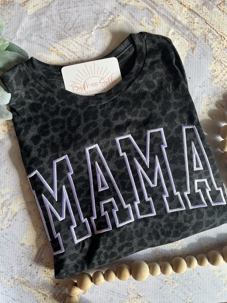 "Love this tee but looking for a different name?! I got you, boo! Just message me for a custom order. Fees may apply.  Looking for the matching Mini shirt? Here's the link: https://www.etsy.com/ByMissSally/listing/1447103037/embroidered-mini-shirt-leopard-mini?utm_source=Copy&utm_medium=ListingManager&utm_campaign=Share&utm_term=so.lmsm&share_time=1679769526224 -------------------------------------------------------------------------------------------------------------------------------- Our shirts:  - Embroidered in South Carolina - Machine wash cold  - Light weight - Iron inside out for best results   ----------------------------------------------------------------------------------------------------------------------------------- Shipping Information:  Please note that all our items are Mother's Day Crew Neck Top With Embroidered Text, Mother's Day Embroidered Text Crew Neck Top, Casual T-shirt With Embroidered Text For Mother's Day, Mother's Day Cotton T-shirt With Embroidered Graphics, Mother's Day Cotton Top With Embroidered Graphics, Casual Tops With Embroidered Text For Mother's Day, Casual Top With Embroidered Text For Mother's Day, Black Cotton Tops With Embroidered Text, Black Cotton Top With Embroidered Text