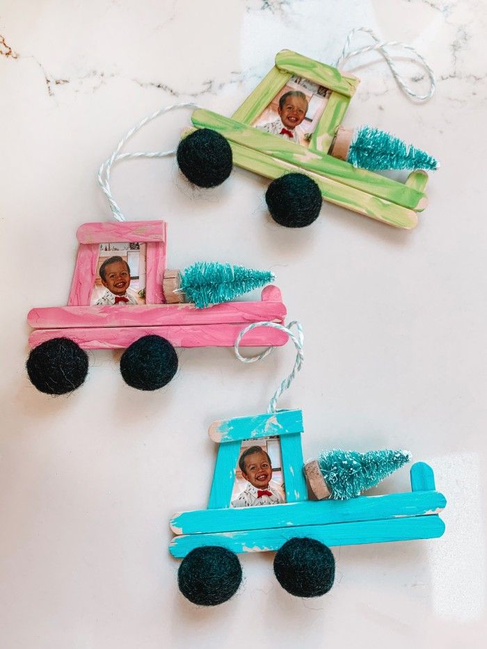 three ornaments made to look like trucks with pictures on them