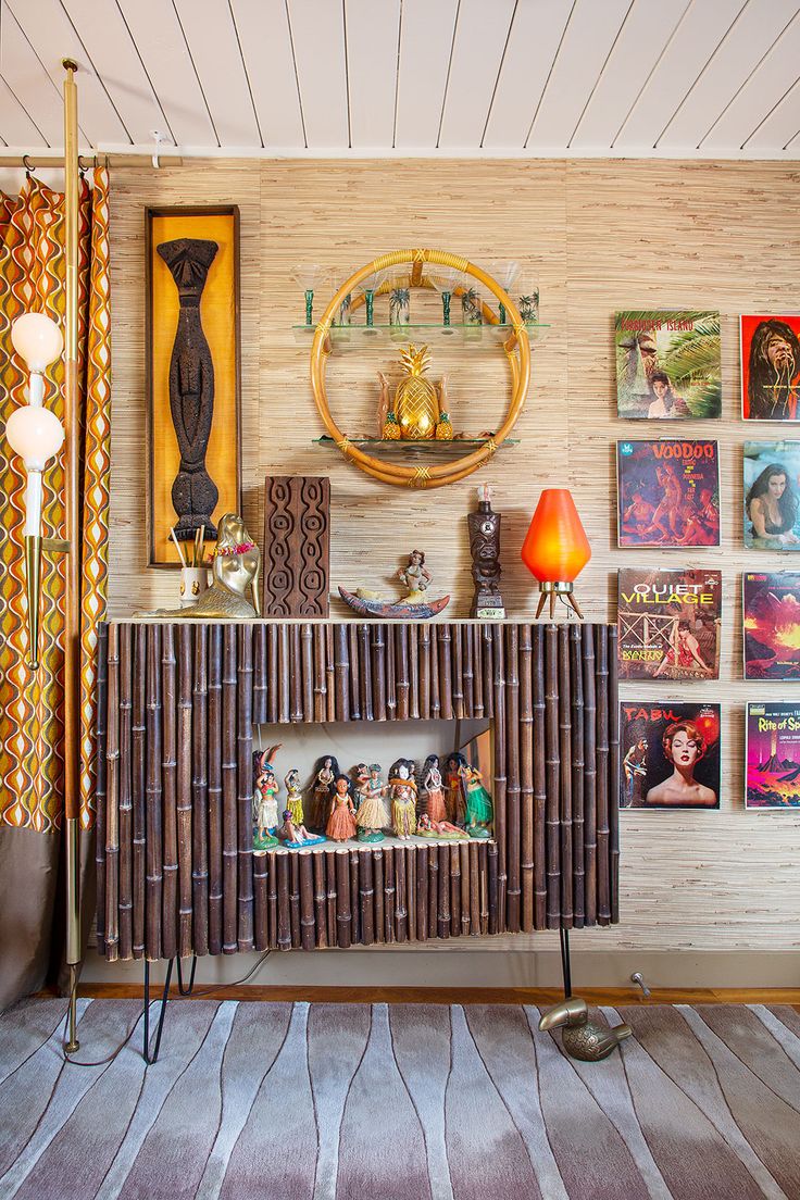 a living room filled with furniture and pictures on the wall next to a table lamp