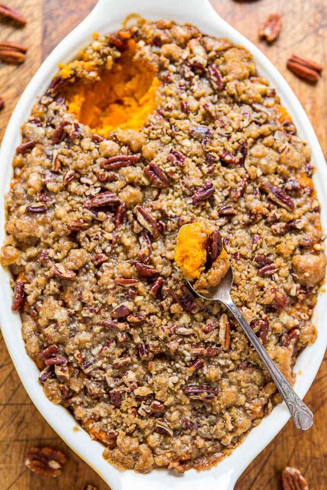 a casserole dish filled with pecans and topped with a spoon